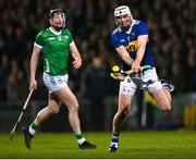25 March 2023; Seámus Kennedy of Tipperary scores a point as Declan Hannon of Limerick looks on during the Allianz Hurling League Division 1 Semi-Final match between Limerick and Tipperary at TUS Gaelic Grounds in Limerick. Photo by Piaras Ó Mídheach/Sportsfile