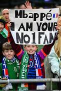 27 March 2023; Supporter Ellie Moran, aged 10, from Bray in Wicklow holds up a sign for Kylian Mbappé of France before the UEFA EURO 2024 Championship Qualifier match between Republic of Ireland and France at Aviva Stadium in Dublin. Photo by Seb Daly/Sportsfile