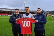 31 March 2023; Luke Byrne of Shelbourne is presented with a shirt to mark his 100th appearance for the club by Shelbourne equipment manager Graham Watson, left, and Karl Watson before the SSE Airtricity Premier Division match between Shelbourne and Derry City at Tolka Park in Dublin. Photo by Seb Daly/Sportsfile