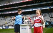 2 April 2023; Hughie Ó Glionnáin from Gaelscoil Bhrian Boróimhe, Swords, Dublin, and Grace Kelly from St. Brigid’s NS, Mayogall, Derry, carry the trophy onto the pitch before the Allianz Football League Division 2 Final match between Dublin and Derry at Croke Park in Dublin. Photo by Ramsey Cardy/Sportsfile
