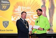 6 April 2023; Mitchell Byrne of Rathfarnham WSAF AC, Dublin, right, who finished second, receives his prize from Cathaoirleach Pat Fitzpatrick after the Peugeot Race Series - Streets of Kilkenny 2023 in Kilkenny. Photo by Sam Barnes/Sportsfile