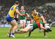 9 April 2023; Jack Coyne of Mayo is tackled by Diarmuid Murtagh, left, and Ben O'Carroll of Roscommon during the Connacht GAA Football Senior Championship Quarter-Final match between Mayo and Roscommon at Hastings Insurance MacHale Park in Castlebar, Mayo. Photo by Ramsey Cardy/Sportsfile