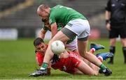 15 April 2023; Shane McGuigan of Derry gets a pass away under pressure from Ryan Lyons, left, and Shea Cullen of Fermanagh during the Ulster GAA Football Senior Championship Quarter-Final match between Fermanagh and Derry at Brewster Park in Enniskillen, Fermanagh. Photo by Ramsey Cardy/Sportsfile