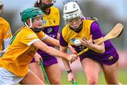 22 April 2023; Sadhbh Buttle of Wexford in action against Eobha McAlister of Antrim during the Electric Ireland Camogie Minor A Shield Semi-Final match between Antrim and Wexford at Coralstown Kinnegad GAA in Westmeath. Photo by Stephen Marken/Sportsfile