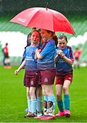 22 April 2023; Piltown AFC players, including Leah Purcell, centre, shelter from the rain with an umbrella during the Aviva Soccer Sisters Finals Day at the Aviva Stadium in Dublin. Photo by Sam Barnes/Sportsfile