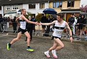 23 April 2023; John Travers of Donore Harriers AC, Dublin, left, hands over to team-mate Josh O'Sullivan-Hourihan, whilst competing in the senior men's event during the 123.ie National Road Relay Championships at Raheny in Dublin. Photo by Sam Barnes/Sportsfile