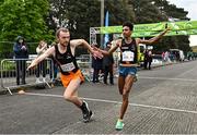 23 April 2023; Efrem Gidey of Clonliffe Harriers, right, hands over to team-mate Jayme Rossiter on their way to winning the senior men's event during the 123.ie National Road Relay Championships at Raheny in Dublin. Photo by Sam Barnes/Sportsfile