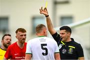 29 April 2023; Referee Alin Suteu shows a yellow card to Paul Breen of St Michael's AFC during the FAI Junior Cup Final match between St Michael’s AFC and Newmarket Celtic at Jackman Park in Limerick. Photo by Seb Daly/Sportsfile
