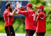 18 May 2023; Tyrone Kane of Munster Reds, right celebrates with teammates PJ Moor, centre, and Liam McCarthy after Simi Singh of Leinster Lightning was caught out during the Rario Inter-Provincial Cup match between Leinster Lightning and Munster Reds at Pembroke Cricket Club in Dublin. Photo by Tyler Miller/Sportsfile