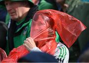 21 May 2023; A Limerick supporter tries to put on a rain jacket during the Munster GAA Hurling Senior Championship Round 4 match between Tipperary and Limerick at FBD Semple Stadium in Thurles, Tipperary. Photo by Piaras Ó Mídheach/Sportsfile