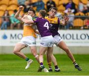 10 June 2023; Cian Farrell of Offaly is tackled by Michael Furlong, left, and Liam Coleman of Wexford during the Tailteann Cup Preliminary Quarter Final match between Offaly and Wexford at Glenisk O'Connor Park in Tullamore, Offaly. Photo by Tom Beary/Sportsfile