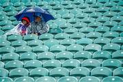 18 June 2023; Supporters take shelter from the rain before the GAA Football All-Ireland Senior Championship Round 3 match between Cork and Mayo at TUS Gaelic Grounds in Limerick. Photo by Eóin Noonan/Sportsfile