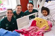 26 June 2023; Republic of Ireland players, from left, Chloe Mustaki, Harriet Scott and Ciara Grant, with Rida Jethva, age 4, from Castleknock, Dublin, during a visit to Temple Street Children's Hospital in Dublin. Photo by Ramsey Cardy/Sportsfile