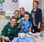 26 June 2023; Republic of Ireland players, from left, Harriet Scott, Ciara Grant and Chloe Mustaki, with Caimin Dolan, age 7, from Carrigallen, Leitrim, during a visit to Temple Street Children's Hospital in Dublin. Photo by Ramsey Cardy/Sportsfile