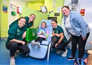 26 June 2023; Republic of Ireland players, from left, Harriet Scott, Chloe Mustaki and Ciara Grant, with Erin Breen, age 7, from Artane, Dublin, during a visit to Temple Street Children's Hospital in Dublin. Photo by Ramsey Cardy/Sportsfile