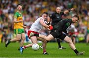 24 June 2023; Donegal goalkeeper Shaun Patton is tackled by Ruairi Canavan of Tyrone during the GAA Football All-Ireland Senior Championship Preliminary Quarter Final match between Donegal and Tyrone at MacCumhaill Park in Ballybofey, Donegal. Photo by Brendan Moran/Sportsfile