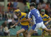 26 June 2004; Tony Griffin, Clare, is tackled by Paul Cuddy, Laois. Guinness Senior Hurling Championship Qualifier, Round 1, Clare v Laois, Gaelic Grounds, Limerick. Picture credit; Pat Murphy / SPORTSFILE