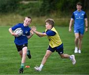 5 July 2023; Paddy McNaughton, left, and Johnny Maguire watched by Leinster player Rob Russell during a Bank of Ireland Leinster Rugby Summer Camp at Stillorgan-Rathfarnham RFC in Dublin. Photo by Harry Murphy/Sportsfile