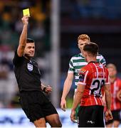 26 June 2023; Adam O'Reilly of Derry City is shown a yellow card by referee Rob Hennessy during the SSE Airtricity Men's Premier Division match between Shamrock Rovers and Derry City at Tallaght Stadium in Dublin. Photo by Stephen McCarthy/Sportsfile