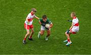 16 July 2023; Harry Kavanagh, Scoil Naomh losaf, Baltinglass, Wicklow, representing Kerry in action against Noah McGuire, Scoil An Chaisil, Glean cholm Cille, Donegal, left, and Oisin Ó hir, Gaelscoil Cois Feabhaill, Moville, Dún na nGall, representing Derry ,during the INTO Cumann na mBunscol GAA Respect Exhibition Go Games at the GAA Football All-Ireland Senior Championship Semi-Final match between Derry and Kerry at Croke Park in Dublin. Photo by Daire Brennan/Sportsfile