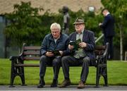 22 July 2023; Racegoers study the form ahead of racing on day one of the Juddmonte Irish Oaks Weekend at The Curragh Racecourse in Kildare. Photo by Seb Daly/Sportsfile