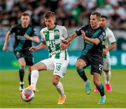 27 July 2023; David Siger of Ferencvaros in action against Liam Burt of Shamrock Rovers during the UEFA Europa Conference League Second Qualifying Round First Leg match between Ferencvaros and Shamrock Rovers at Ferencváros Stadion in Budapest, Hungary. Photo by David Balogh/Sportsfile