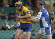 26 June 2004; Tony Griffin, Clare, is tackled by Paul Cuddy, Laois. Guinness Senior Hurling Championship Qualifier, Round 1, Clare v Laois, Gaelic Grounds, Limerick. Picture credit; Pat Murphy / SPORTSFILE
