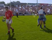 27 June 2004; Waterford's Brian Phelan and Eoin McGrath are congratulated by a supporter while Cork's Brian Murphy shows his dissapointment as he leaves the field. Guinness Munster Senior Hurling Championship Final, Cork v Waterford, Semple Stadium, Thurles, Co. Tipperary. Picture credit; Ray McManus / SPORTSFILE