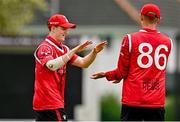 3 August 2023; Mike Frost of Munster Reds, left, and team-mate Ben White celebrate the wicket of  Craig Young of North West Warriors  during the Rario Inter-Provincial Trophy 2023 match between North West Warriors and Munster Reds at Pembroke Cricket Club in Dublin. Photo by Sam Barnes/Sportsfile