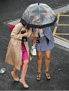 3 August 2023; Racegoers shelter from the rain during day four of the Galway Races Summer Festival at Ballybrit Racecourse in Galway. Photo by Seb Daly/Sportsfile