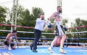 4 August 2023; Lewis Crocker, right, after knocking down Greyvin Mendoza in the fourth round of their welterweight bout during the Féile Fight Night at Falls Park in Belfast. Photo by Ramsey Cardy/Sportsfile