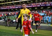 6 August 2023; Manchester United mascot Finn O'Shea, age 9, from Clonmel, Tipperary walks out with Tom Heaton of Manchester United before the pre-season friendly match between Manchester United and Athletic Bilbao at the Aviva Stadium in Dublin. Photo by David Fitzgerald/Sportsfile