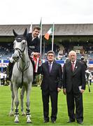 9 August 2023; Shane Sweetnam of Ireland on Out Of The Blue SCF, left, is presented with his rosette by Sport Ireland Chairman John Foley, centre, and RDS President John Dardis, right,  after winning the Longines FEI Dublin Horse Show - Sport Ireland Classic at the RDS in Dublin. Photo by Sam Barnes/Sportsfile