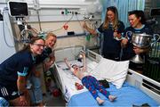 14 August 2023; Noah Quish, age 6, from Monaleen, Limerick with Dublin ladies players, from left, Orlagh Nolan, Carla Rowe, Grainne Fitzsimons and Leah Caffrey and the Brendan Martin Cup on a visit to CHI at Temple Street, Dublin. Photo by David Fitzgerald/Sportsfile