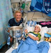 14 August 2023; Mia Healy Duggan, age 11, from Terenure, Dublin with Dublin ladies captain Carla Rowe and the Brendan Martin Cup on a visit to CHI at Temple Street, Dublin. Photo by David Fitzgerald/Sportsfile