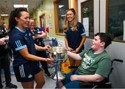 14 August 2023; Andre van Wyk, age 11, from Portmarnock, Dublin with Dublin ladies players, Leah Caffrey, left, and Grainne Fitzsimons and the Brendan Martin Cup on a visit to CHI at Temple Street, Dublin. Photo by David Fitzgerald/Sportsfile