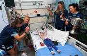 14 August 2023; Noah Quish, age 6, from Monaleen, Limerick with Dublin ladies players, from left, Orlagh Nolan, Carla Rowe, Grainne Fitzsimons and Leah Caffrey and the Brendan Martin Cup on a visit to CHI at Temple Street, Dublin. Photo by David Fitzgerald/Sportsfile