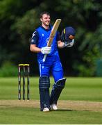14 Augut 2023; Lorcan Tucker of Leinster Lightning holds his bat aloft after bringing up his century of runs during the Rario Inter-Provincial Cup match between Leinster Lightning and North West Warriors at The Hills Cricket Club in Dublin. Photo by Tyler Miller/Sportsfile