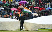 18 August 2023; Spectators watch as ground staff bring on the covers due to rain during match one of the Men's T20 International series between Ireland and India at Malahide Cricket Ground in Dublin. Photo by Seb Daly/Sportsfile