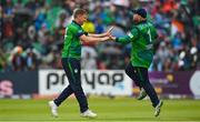 18 August 2023; Ireland bowler Craig Young, left, is congratulated by teammate Paul Stirling after claiming the wicket of India's Tilak Varma during match one of the Men's T20 International series between Ireland and India at Malahide Cricket Ground in Dublin. Photo by Seb Daly/Sportsfile