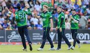 20 August 2023; Barry McCarthy of Ireland, second from left, is congratulated by teammate George Dockrell, left. after claiming the wicket of India's Ruturaj Gaikwad during match two of the Men's T20 International series between Ireland and India at Malahide Cricket Ground in Dublin. Photo by Seb Daly/Sportsfile