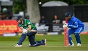 20 August 2023; Ireland batter Andrew Balbirnie plays a shot, watched by India wicketkeeper Sanju Samson, during match two of the Men's T20 International series between Ireland and India at Malahide Cricket Ground in Dublin. Photo by Seb Daly/Sportsfile