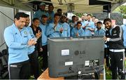 23 August 2023; India players and staff applaud as they watch a television, broadcasting Indian Space Research Organisation's Chandrayaan-3 landing on the moon, before match three of the Men's T20 International series between Ireland and India at Malahide Cricket Ground in Dublin. Photo by Seb Daly/Sportsfile