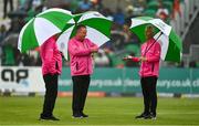 23 August 2023; Umpires, from left, Mark Hawthorne, Jareth McCready and Paul Reynolds inspect the covers and outfield as rain delays play ahead of match three of the Men's T20 International series between Ireland and India at Malahide Cricket Ground in Dublin. Photo by Seb Daly/Sportsfile