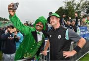 23 August 2023; Mark Adair of Ireland poses for a selfie with a spectator, as rain delays play, ahead of match three of the Men's T20 International series between Ireland and India at Malahide Cricket Ground in Dublin. Photo by Seb Daly/Sportsfile