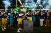 26 August 2023; Notre Dame wide receiver Jayden Thomas #83, left, and offensive lineman Blake Fisher #54 lift the Keough - Naughton College Football Ireland trophy after the Aer Lingus College Football Classic match between Notre Dame and Navy Midshipmen at the Aviva Stadium in Dublin. Photo by Brendan Moran/Sportsfile