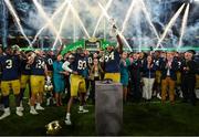 26 August 2023; Notre Dame offensive lineman Blake Fisher #54, right, lifts the Keough - Naughton College Football Ireland trophy after the Aer Lingus College Football Classic match between Notre Dame and Navy Midshipmen at the Aviva Stadium in Dublin. Photo by Brendan Moran/Sportsfile