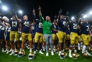 26 August 2023; Notre Dame head coach Marcus Freeman, centre, celebrates with his players after their side's victory in the Aer Lingus College Football Classic match between Notre Dame and Navy Midshipmen at the Aviva Stadium in Dublin. Photo by Ben McShane/Sportsfile