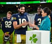 26 August 2023; Notre Dame quarterback Sam Hartman #10 is presented with the MVP award by  Aer Lingus cabin crew member Carla McMahon after the Aer Lingus College Football Classic match between Notre Dame and Navy Midshipmen at the Aviva Stadium in Dublin. Photo by Brendan Moran/Sportsfile