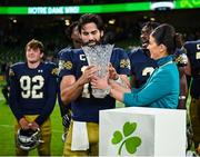 26 August 2023; Notre Dame quarterback Sam Hartman #10 is presented with the MVP award by  Aer Lingus cabin crew member Carla McMahon after the Aer Lingus College Football Classic match between Notre Dame and Navy Midshipmen at the Aviva Stadium in Dublin. Photo by Brendan Moran/Sportsfile